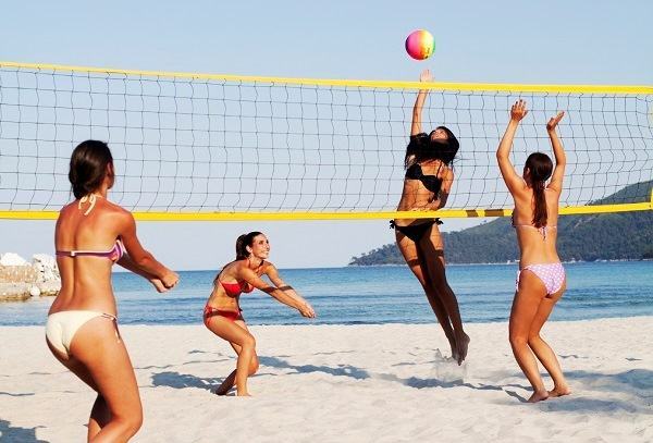 Quattro donne giocano a beach volley sulla sabbia