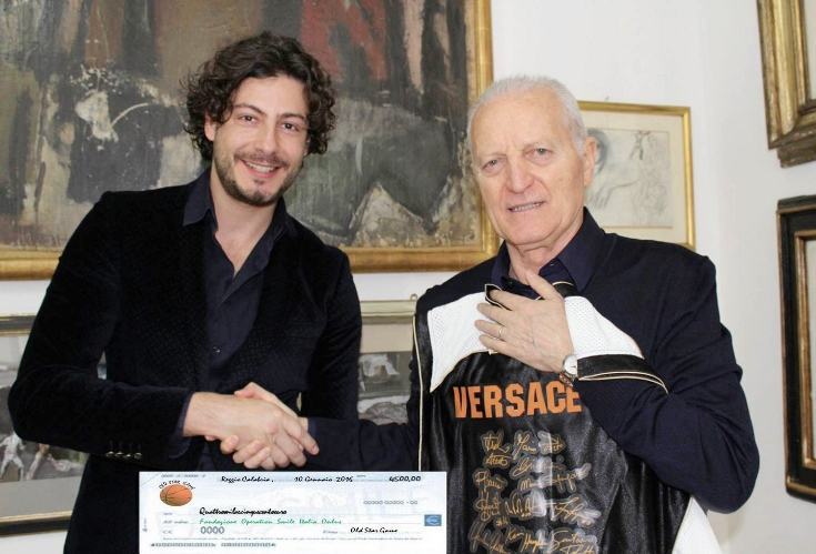 Ale Nava consegna l'assegno a Santo Versace, presidente di Operation Smile Italia