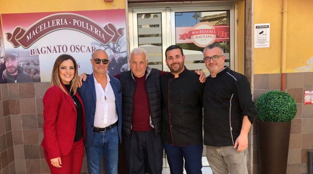 Cinque persone posano davanti alla Macelleria Bagnato di Reggio Calabria, durante la visita di Stanley Tucci