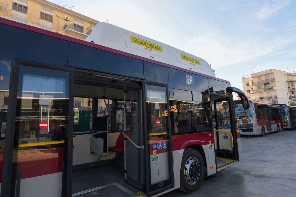 Autobus a metano della flotta ATAM in sosta in un piazzale, con altri mezzi sullo sfondo