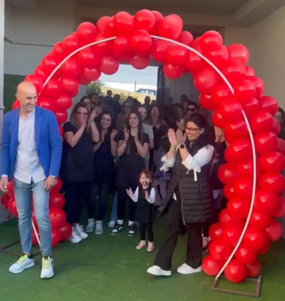 Inaugurazione della sala feste Il mondo delle Farfalle: arco di palloncini rossi, applausi e una bambina al centro