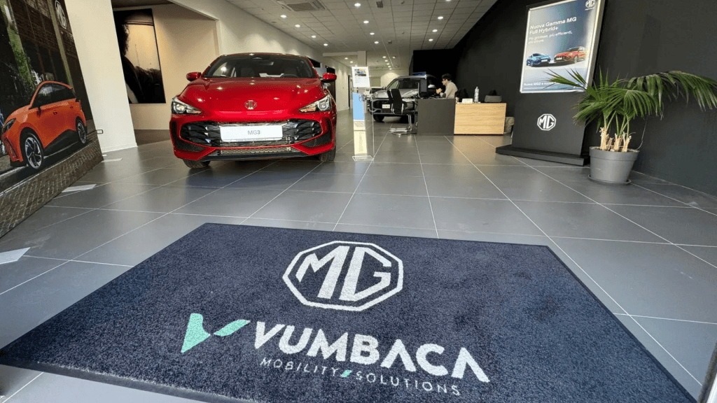 Showroom Vumbaca con una MG3 rossa esposta e lo zerbino con il logo MG e Vumbaca Mobility Solutions