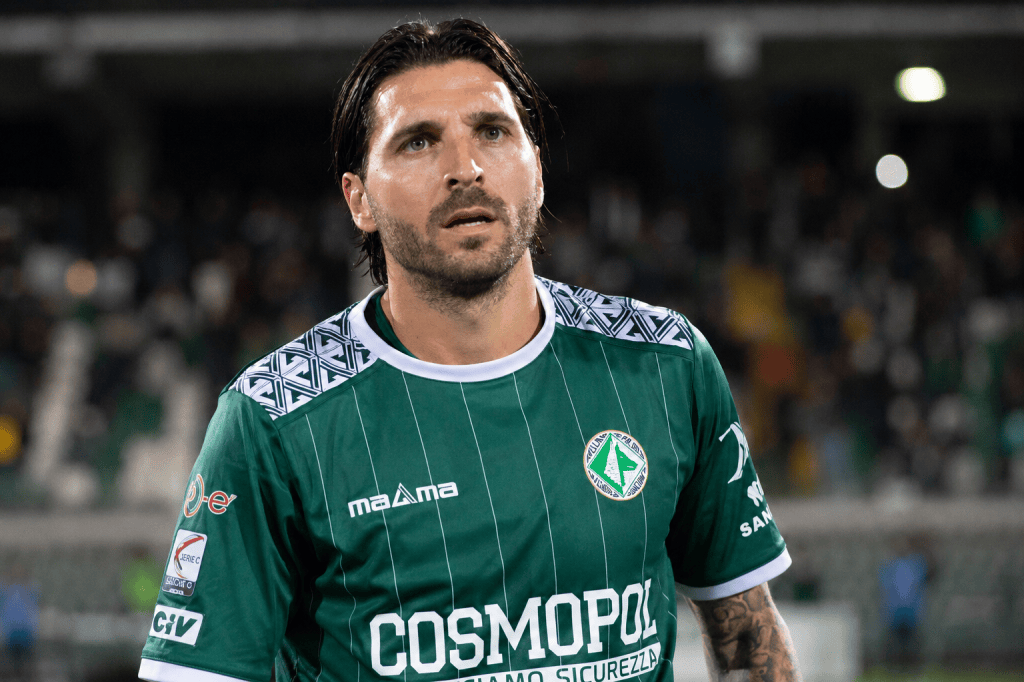 Cosimo Patierno in maglia verde dell'Avellino con sponsor Cosmopol, in campo davanti alle tribune
