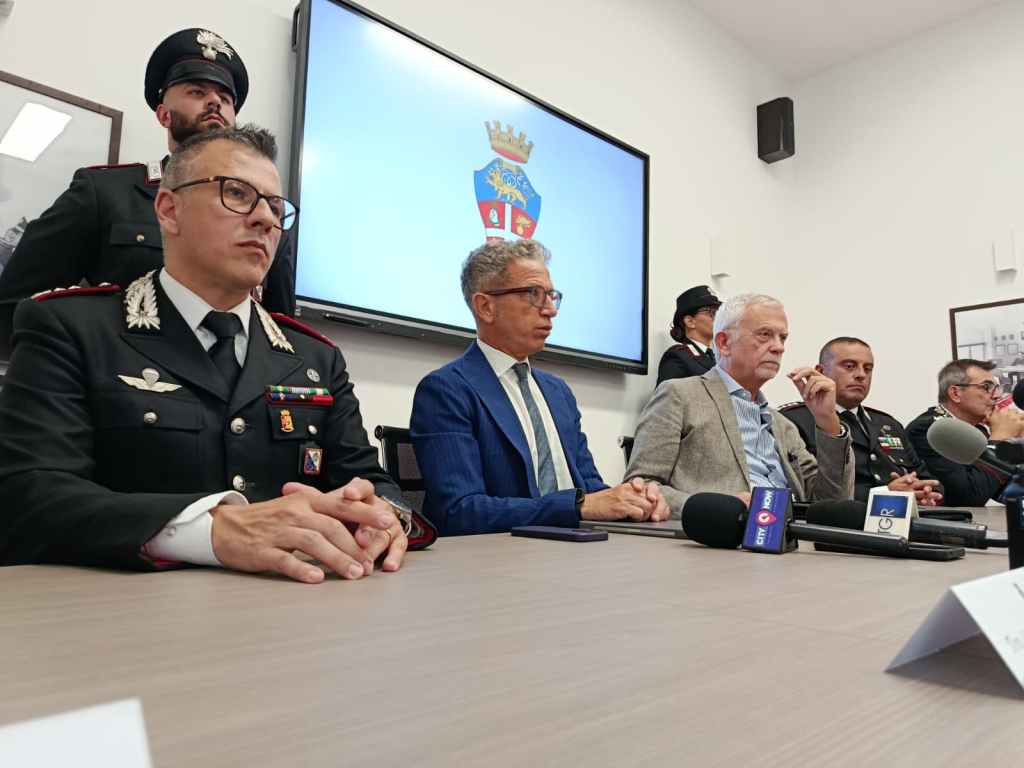 Conferenza stampa dei Carabinieri con Musolino e Borrelli tra i relatori al tavolo, sullo schermo lo stemma dell'Arma