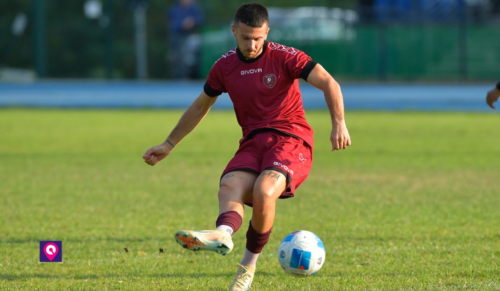 Riccardo Rotulo della Reggina in maglia amaranto calcia il pallone durante un allenamento