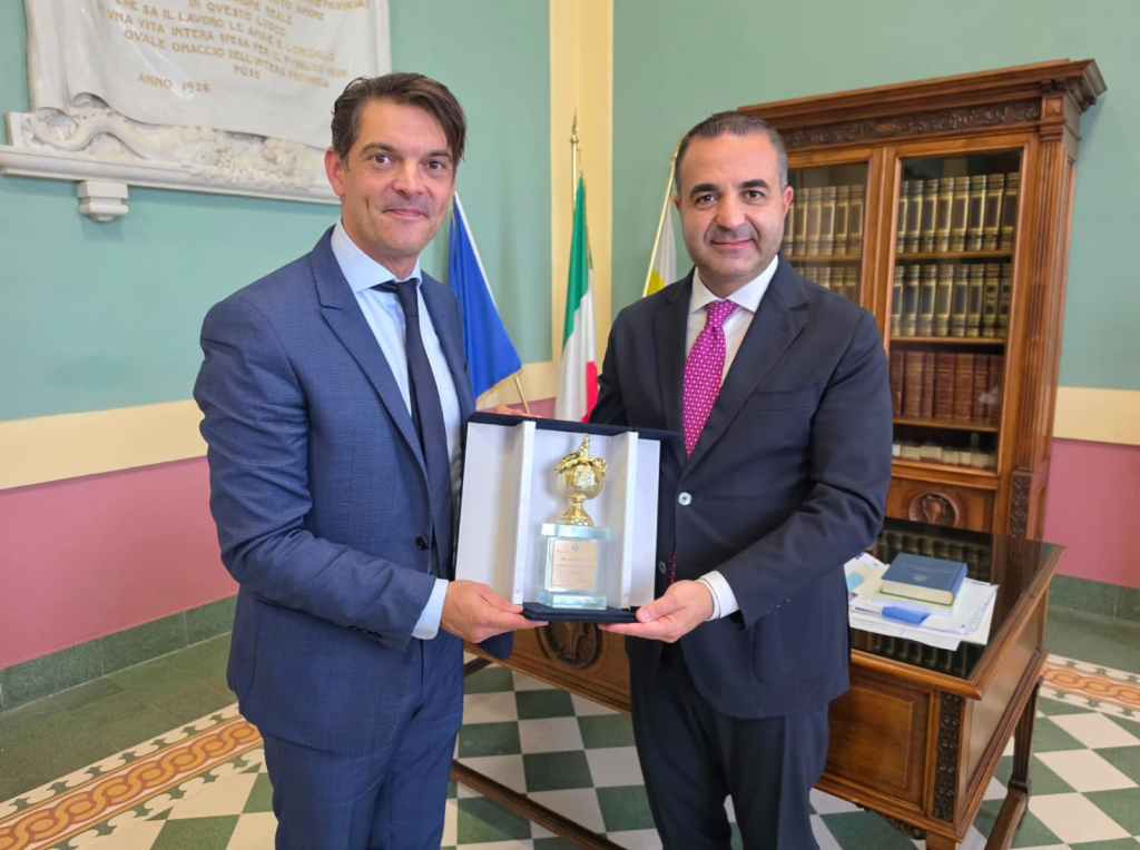 Il sindaco Francesco Cannizzaro e il sindaco di Grasse Jérôme Viaud reggono un riconoscimento dorato in un astuccio a Palazzo Alvaro