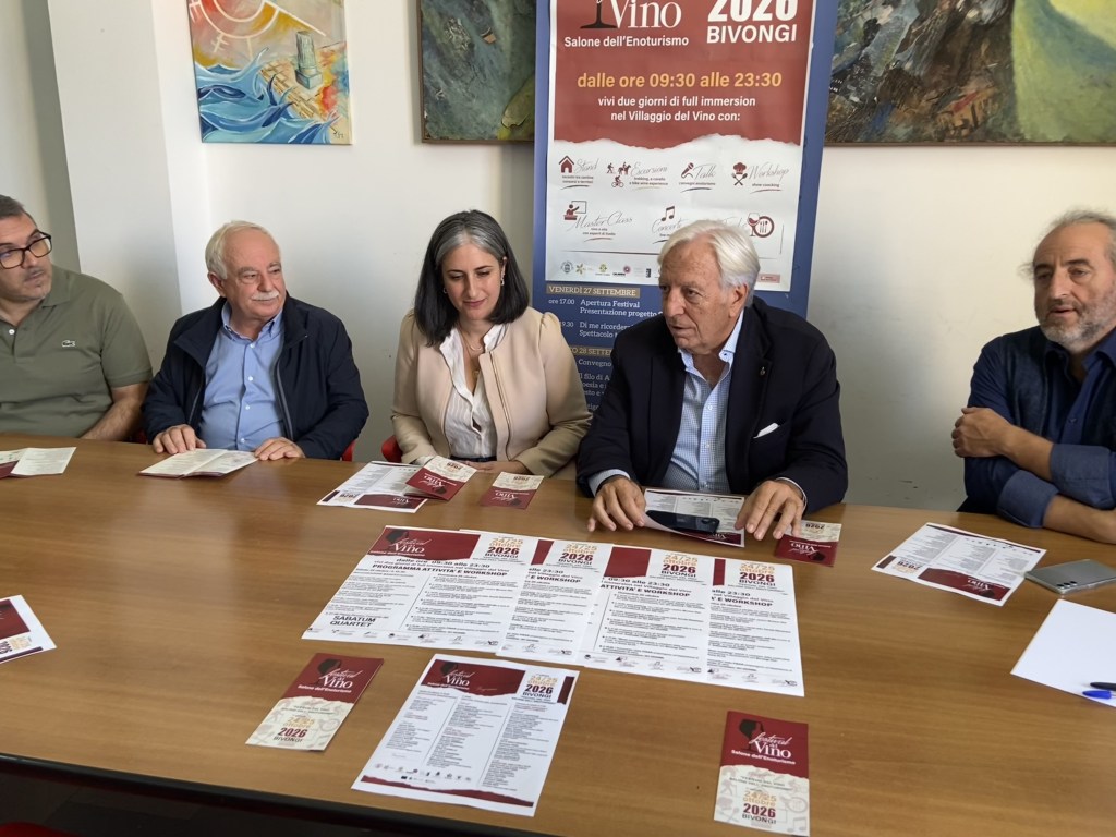 Cinque relatori seduti a un tavolo con i volantini del Festival del Vino, alle spalle il manifesto dell'evento