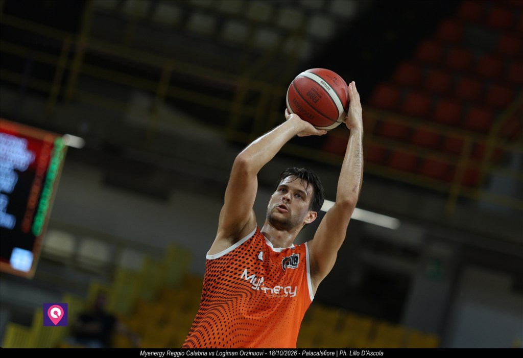 Giocatore della Pallacanestro Viola in maglia arancione Myenergy tira a due mani sopra la testa durante la partita