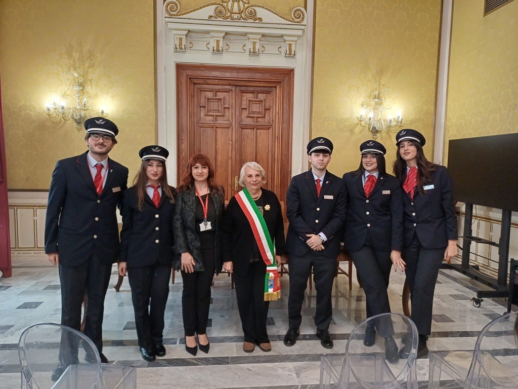 Cinque nuovi capitreno in divisa posano con due donne, una con la fascia tricolore, in una sala del Comune di Reggio Calabria